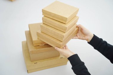 A woman holds cardboard boxes for parcels and delivery