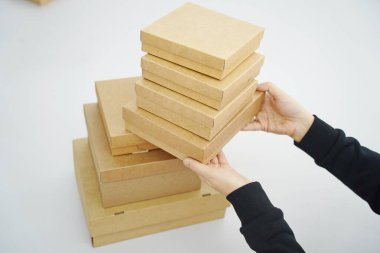 A woman holds cardboard boxes for parcels and delivery