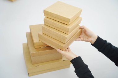 A woman holds cardboard boxes for parcels and delivery