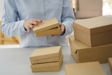 A woman holds cardboard boxes for parcels and delivery