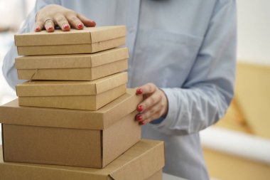 A woman holds cardboard boxes for parcels and delivery