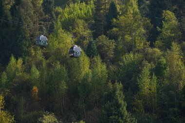 Almaty, Kazakhstan - 09.16.2022 : The cabs of the funicular go along the forest in the mountainous area of Medeo.