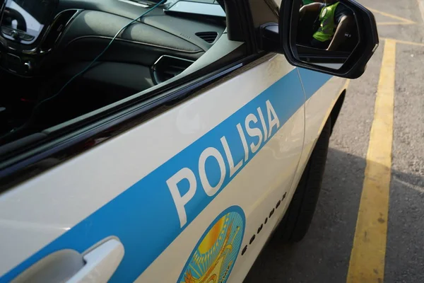 Almaty, Kazakhstan - 09.16.2022 : The police officer is partially displayed in the mirror of the patrol car.