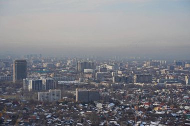 Almaty, Kazakhstan - 01.31.2023 : Residential and commercial buildings of the city and smog over the entire territory.
