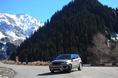 Almaty, Kazakistan - 02.29.2016: Bir Range Rover Evoque aracının kış mevsiminde dağlık bir alanda test sürüşü.