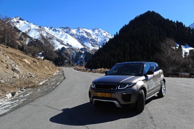 Almaty, Kazakistan - 02.29.2016: Bir Range Rover Evoque aracının kış mevsiminde dağlık bir alanda test sürüşü.