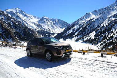 Almaty, Kazakistan - 02.29.2016: Bir Range Rover Evoque aracının kış mevsiminde dağlık bir alanda test sürüşü.