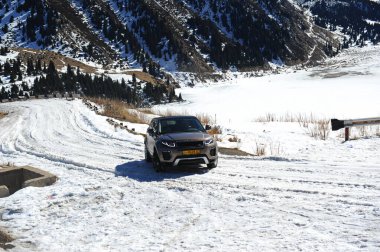 Almaty, Kazakistan - 02.29.2016: Bir Range Rover Evoque aracının kış mevsiminde dağlık bir alanda test sürüşü.