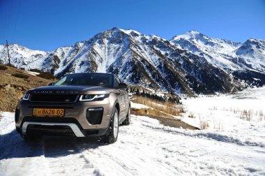 Almaty, Kazakistan - 02.29.2016: Bir Range Rover Evoque aracının kış mevsiminde dağlık bir alanda test sürüşü.