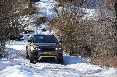 Almaty, Kazakistan - 02.29.2016: Bir Range Rover Evoque aracının kış mevsiminde dağlık bir alanda test sürüşü.
