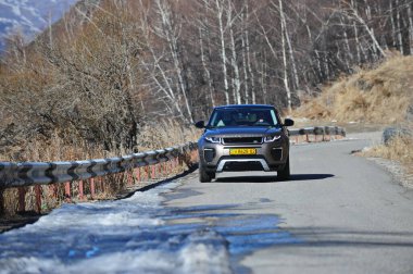 Almaty, Kazakistan - 02.29.2016: Bir Range Rover Evoque aracının kış mevsiminde dağlık bir alanda test sürüşü.