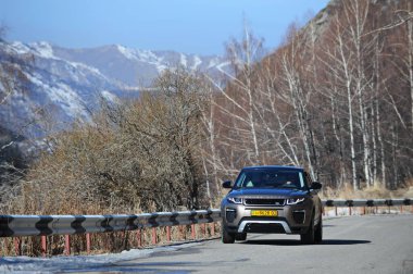 Almaty, Kazakistan - 02.29.2016: Bir Range Rover Evoque aracının kış mevsiminde dağlık bir alanda test sürüşü.