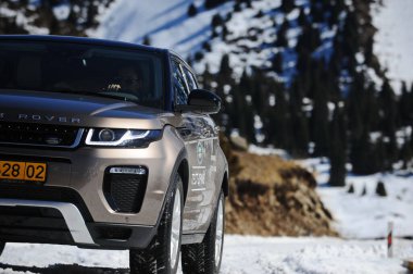 Almaty, Kazakistan - 02.29.2016: Bir Range Rover Evoque aracının kış mevsiminde dağlık bir alanda test sürüşü.