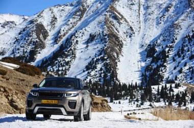 Almaty, Kazakistan - 02.29.2016: Bir Range Rover Evoque aracının kış mevsiminde dağlık bir alanda test sürüşü.