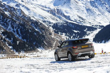 Almaty, Kazakistan - 02.29.2016: Bir Range Rover Evoque aracının kış mevsiminde dağlık bir alanda test sürüşü.