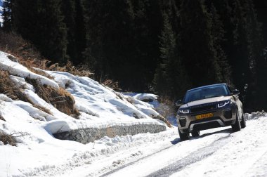 Almaty, Kazakistan - 02.29.2016: Bir Range Rover Evoque aracının kış mevsiminde dağlık bir alanda test sürüşü.