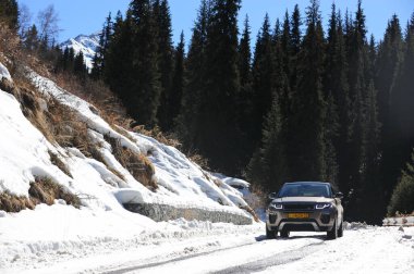 Almaty, Kazakistan - 02.29.2016: Bir Range Rover Evoque aracının kış mevsiminde dağlık bir alanda test sürüşü.