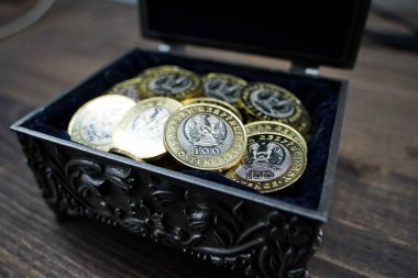 Almaty, Kazakistan - 04.05.2023: 100 Kazakistan tentesi yüzölçümü olan bir avuç dolusu bozuk para bir tabutta katlandı.