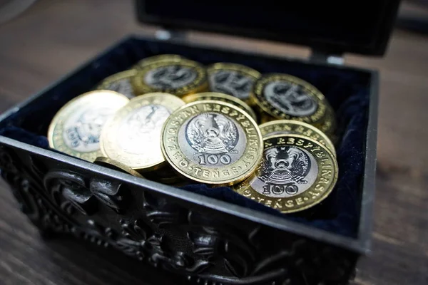 カザフスタンのアルマティ 2023年 顔の価値が100カザフスタンテンジの大きな一握りのコインが棺に折り畳まれている ロイヤリティフリーのストック写真