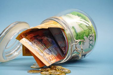 Almaty, Kazakistan - 04.05.2023: Banknotlar ve madeni paralarla dolu bir kavanoz.
