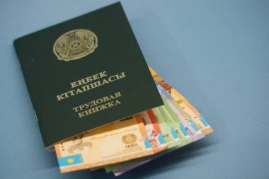 Almaty, Kazakistan - 04.05.2023: Kazakistan Cumhuriyeti 'nin çalışma kitabı ve farklı mezheplerin banknotları
