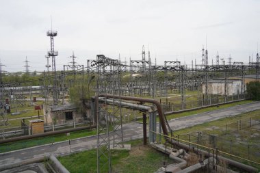 Almaty, Kazakistan - 04.17.2023: Isıtma tesisinde indüktörler ve dengeleyicilerle elektrik hatları.