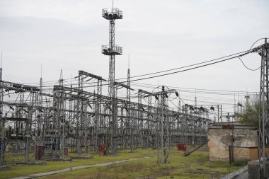 Almaty, Kazakistan - 04.17.2023: Isıtma tesisinde indüktörler ve dengeleyicilerle elektrik hatları.