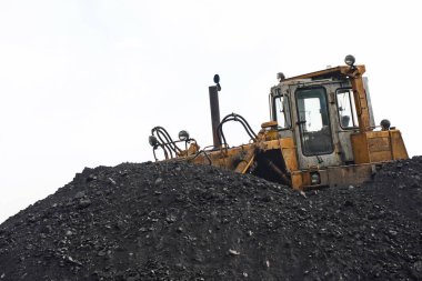 Almaty, Kazakistan - 04.17.2023: Kazıcı ısıtma tesisinin deposunda kömür topluyor.