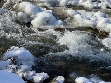 Kışın dağlık bir bölgede bir nehir. Fırtınalı bir dere.