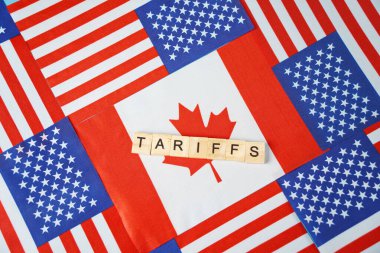 Yazı: Kanada bayrağının arka planındaki tarifeler ve ABD bayrakları..