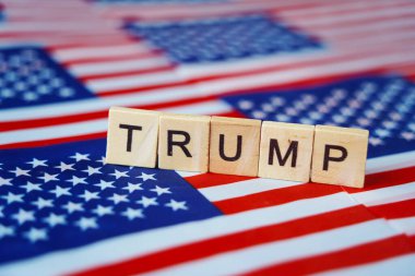ABD bayraklarının arkaplanındaki Trump yazısı.