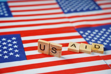 ABD bayraklarının arkaplanındaki USAID yazıları.