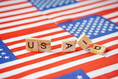 ABD bayraklarının arkaplanındaki USAID yazıları.