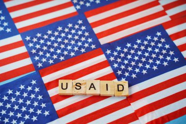 ABD bayraklarının arkaplanındaki USAID yazıları.