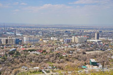 Almaty, Kazakistan - 04.07.2025: Şehir manzarası ve merkez caddelerden biri. Farklı mimari. Bahar geldi..