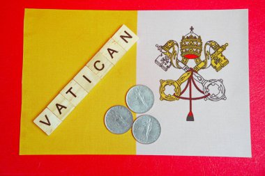 Vatikan yazıtları ve bayrağın arka planındaki madeni paralar