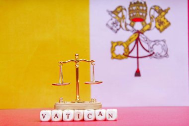 Vatikan bayrağının arka planında küçük pullar ve Vatikan yazıtları var..