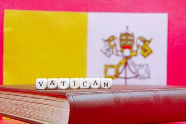 Bayrağın arka planında Vatikan yazıları var.