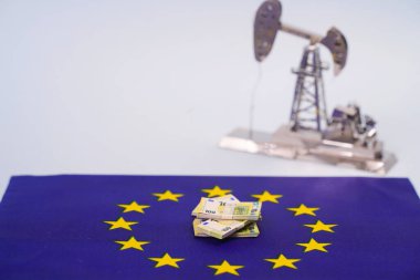 Avrupa Birliği bayrağı ve petrol platformunun arka planında Avro banknotları.