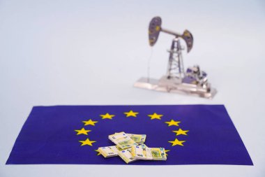 Avrupa Birliği bayrağı ve petrol platformunun arka planında Avro banknotları.