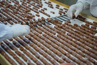 İşçiler çikolataları ayırır. Fabrika.