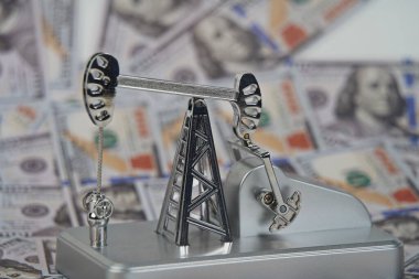 Amerikan doları banknotlarının arka planında bir petrol platformu.