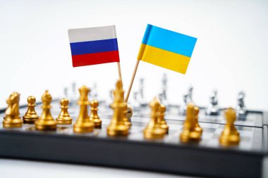 Rusya ve Ukrayna 'nın parçalarının ve bayraklarının olduğu bir satranç tahtası. Strateji, politik oyun ve diplomasi.