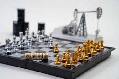 OPEC kelimesi. Parçalı bir satranç tahtası, yağ varilleri ve arka planda bir yağ pompası krikosu.