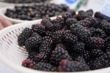 Masadaki büyük tabakta böğürtlenler. Yaz hasadı.