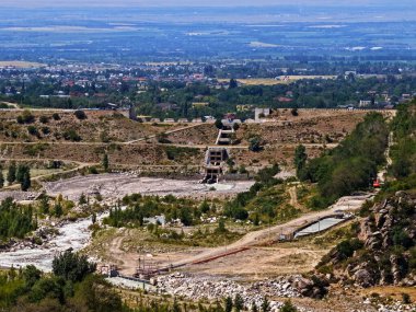 Talgar geçidinde koruyucu bir baraj. Farklı bitki örtüsü ve nehri olan dağlık bir bölge..