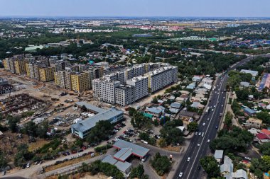 Almaty, Kazakistan - 07.29.2025: Çok katlı binaların inşaatı. Şehrin merkez caddelerinden biri. İnsansız hava aracının görüntüsü.