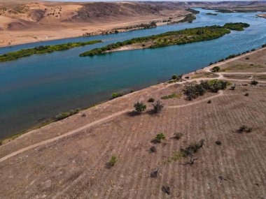 Ili Nehri ve kumlu kıyı bölgesi. Semirechye 'deki en büyük nehir. İnsansız hava aracının görüntüsü. Yılın yaz zamanı..