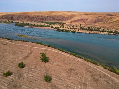 Ili Nehri ve kumlu kıyı bölgesi. Semirechye 'deki en büyük nehir. İnsansız hava aracının görüntüsü. Yılın yaz zamanı..