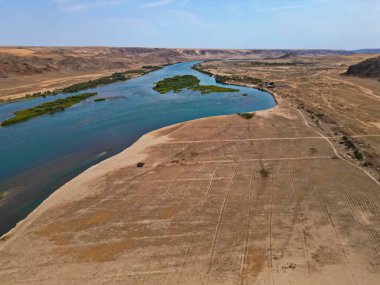 Ili Nehri ve kumlu kıyı bölgesi. Semirechye 'deki en büyük nehir. İnsansız hava aracının görüntüsü. Yılın yaz zamanı..